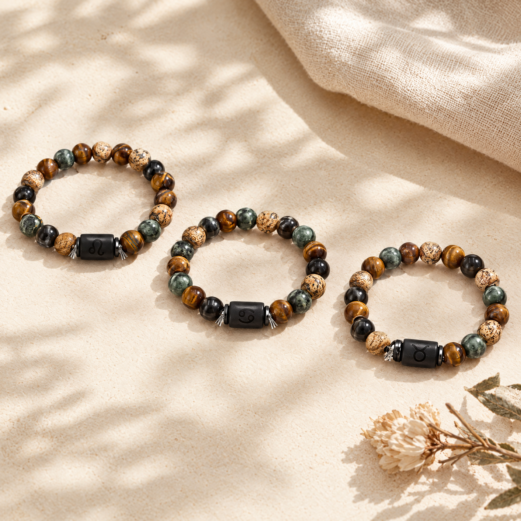 Three zodiac bracelets with different signs in a soft flat-lay